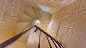 A spiral staircase with a handrail and steps made of stone or concrete. - Cosy Maltese Townhouse, Roof Terrace and Views (Senglea)