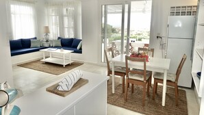 Ein modernes Wohnzimmer mit einer Couch, einem Couchtisch und einem Essbereich mit Stühlen und einem Tisch.