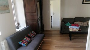 Een woonkamer met een bank, een kast, een divan en een salontafel.