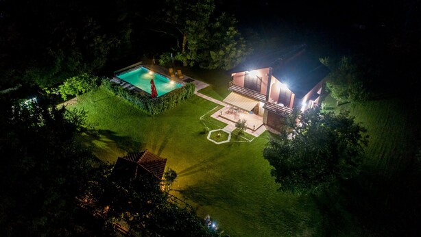 A modern house with a swimming pool and a patio area. - Luxury house with private pool, sauna, hot tub and river on the property (Danilovgrad)