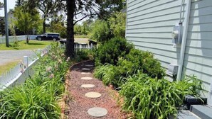A garden pathway with stepping stones leading to a house.