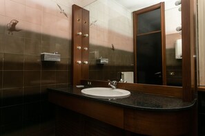 Ein Badezimmer mit Waschbecken, Spiegel und Handtuchhalter.
