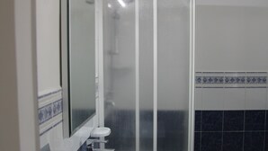Ein Badezimmer mit Waschbecken, Spiegel, Toilette und Duschkabine.