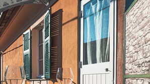 An outdoor dining area with a table set for two, featuring a wine glass and a plate. - Duplex Studio Apartment with Parking and Bike Storage in Chiavari (Chiavari)
