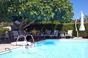 Een seizoensgebonden buitenzwembad, parasols voor strand/zwembad