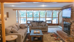 Ein Wohnzimmer mit zwei Sofas, einem Couchtisch und einem Kamin.