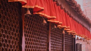 Un edifici tradicional amb una tenda vermella i diverses campanes.