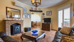 A living room with a fireplace, a television, and a sofa.