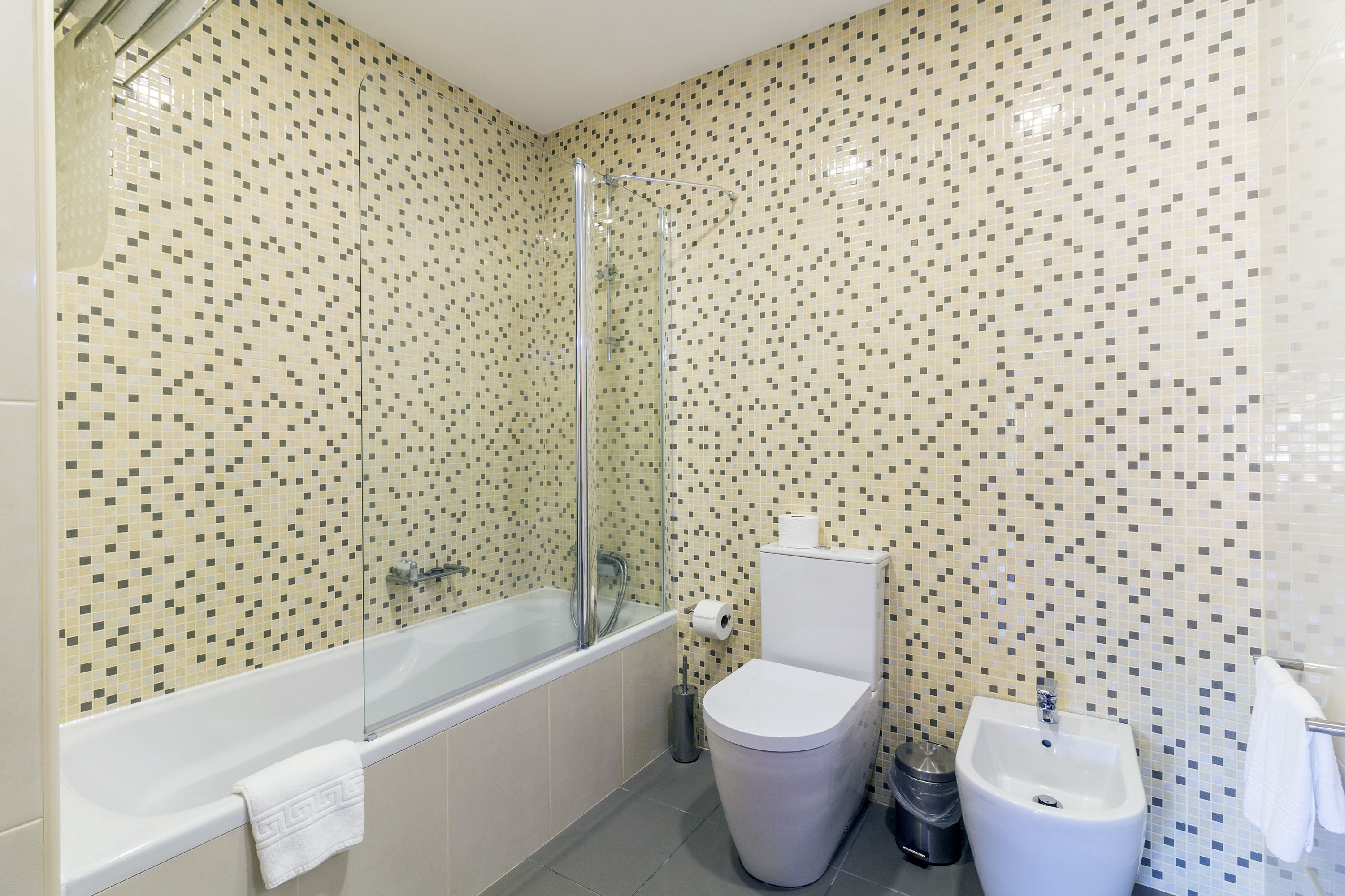 Een badkamer met een bad, toilet en wastafel.
