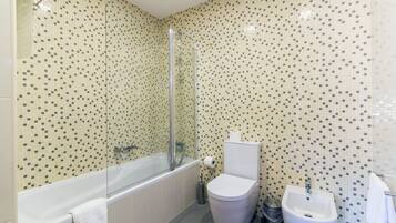 Een badkamer met een bad, toilet en wastafel.