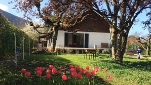 A house with a garden, a swing set, and a person in the background. - SEVRIER,Plain pied, Spacieuse Villa, jardin, 8pers (Sévrier)