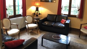 A living room with a sofa, chairs, a table, a lamp, and a radiator. - ST-JORIOZ, maison de famille, 500m du Lac, 10M de la piste cyclable, 10pers (Saint-Jorioz)
