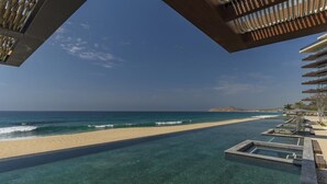 Une piscine à débordement offrant une vue sur la plage et l’océan.