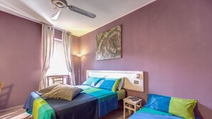 A bedroom with two beds, a ceiling fan, a window with curtains, and a wall-mounted artwork. - COLOSSEUM a stone's throw from (Roma)