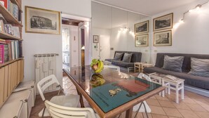 A modern living room with a glass dining table, a sofa, and a bookshelf. - COLOSSEUM a stone's throw from (Roma)