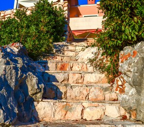 A stone staircase leading up to a building with a red roof.