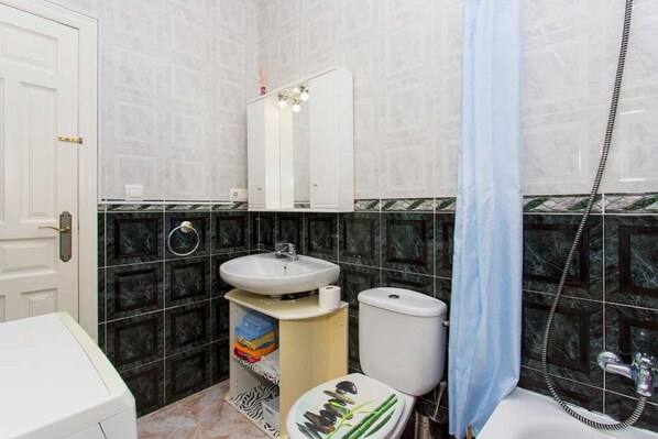 A bathroom with a toilet, sink, and shower.