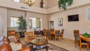 A spacious living room with a leather couch, a coffee table, and a dining area with wooden chairs and a table. - Resort Style Vacation Condo (Mesa)