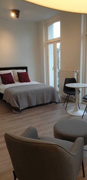Ein modernes Hotelzimmer mit einem Bett, einem runden Tisch und zwei Stühlen.
