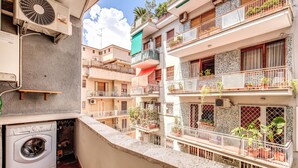 A multi-level residential building with balconies, a washing machine, and potted plants. - Beautiful apartment near San Pietro. Comfortable, silent, WI-FI, accessories. (Roma)