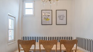 A dining area with a wooden table and chairs, a bench, and two framed quotes on the wall. - Privatzimmer in bester Altstadtlage (Tuebingen)