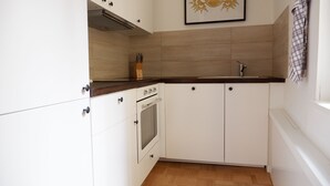 A kitchen with white cabinets, a wooden countertop, a built-in oven, and a sink. - Privatzimmer in bester Altstadtlage (Tuebingen)