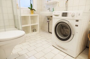 A bathroom with a Bosch washing machine, a toilet, a sink, and a potted plant. - Privatzimmer in bester Altstadtlage (Tuebingen)