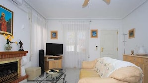 A living room with a television, sofa, and fireplace. - CH Villa Sola Ciudad Quesada (Ciudad Quesada)