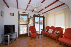 A living room with a television, a ceiling fan, a sofa, and a chair. - CH Villa Sola Ciudad Quesada (Ciudad Quesada)