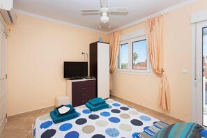 A bedroom with a bed, a television, a wardrobe, and a window with curtains. - CH Villa Sola Ciudad Quesada (Ciudad Quesada)
