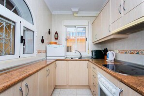 A compact kitchen with a built-in oven, a sink, and a stove. - CH Villa Sola Ciudad Quesada (Ciudad Quesada)