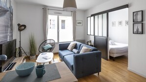Ein modernes Wohnzimmer mit einer Couch, einem Esstisch und einem Fernseher.