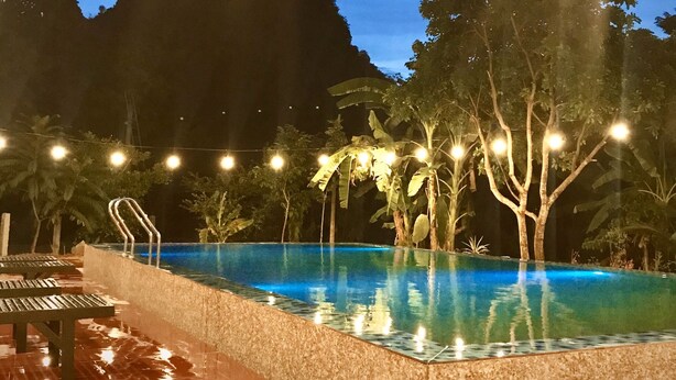 Une piscine avec vue sur les montagnes au crépuscule.