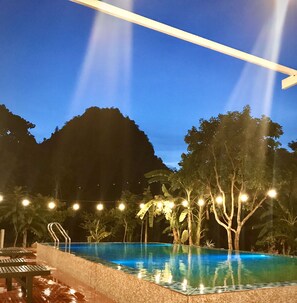 A swimming pool with a view of mountains at dusk. - Phong Nha Love Homestay (Phong Nha)