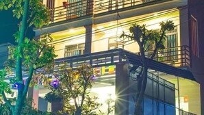 Un hôtel à plusieurs étages, doté de balcons et d’une enseigne sur laquelle on peut lire : « PRING NHA LOVE ».