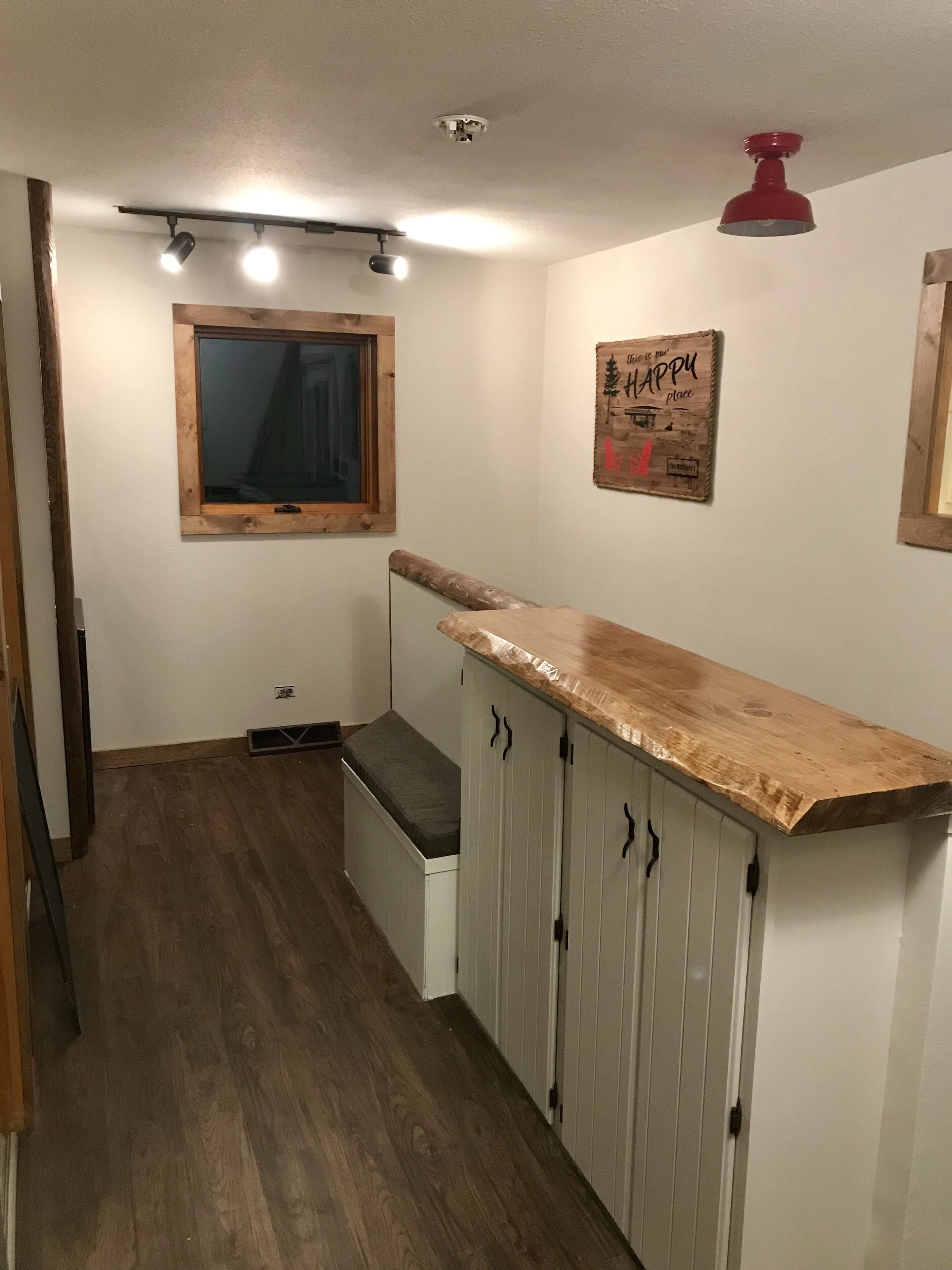 Una cocina con armarios de madera, una encimera, un ventanal y una lámpara en el techo.