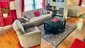 Uma sala de estar moderna com sofá, poltrona, mesa de centro e televisão.