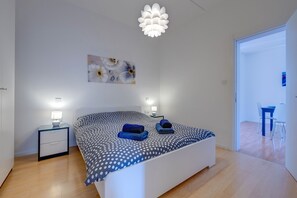 2 dormitorios y tabla de planchar con plancha