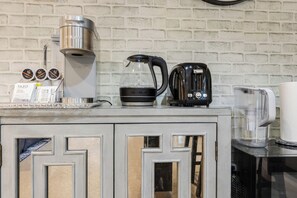 A kitchen with a coffee maker, toaster, and kettle on the counter.