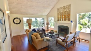 A spacious living room with a fireplace, large windows, and a cozy seating area.