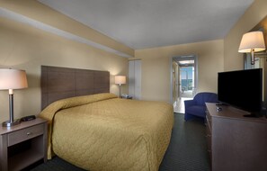 Une chambre d’hôtel avec un grand lit, des lampes de chevet, un bureau avec un téléviseur à écran plat et une chaise.