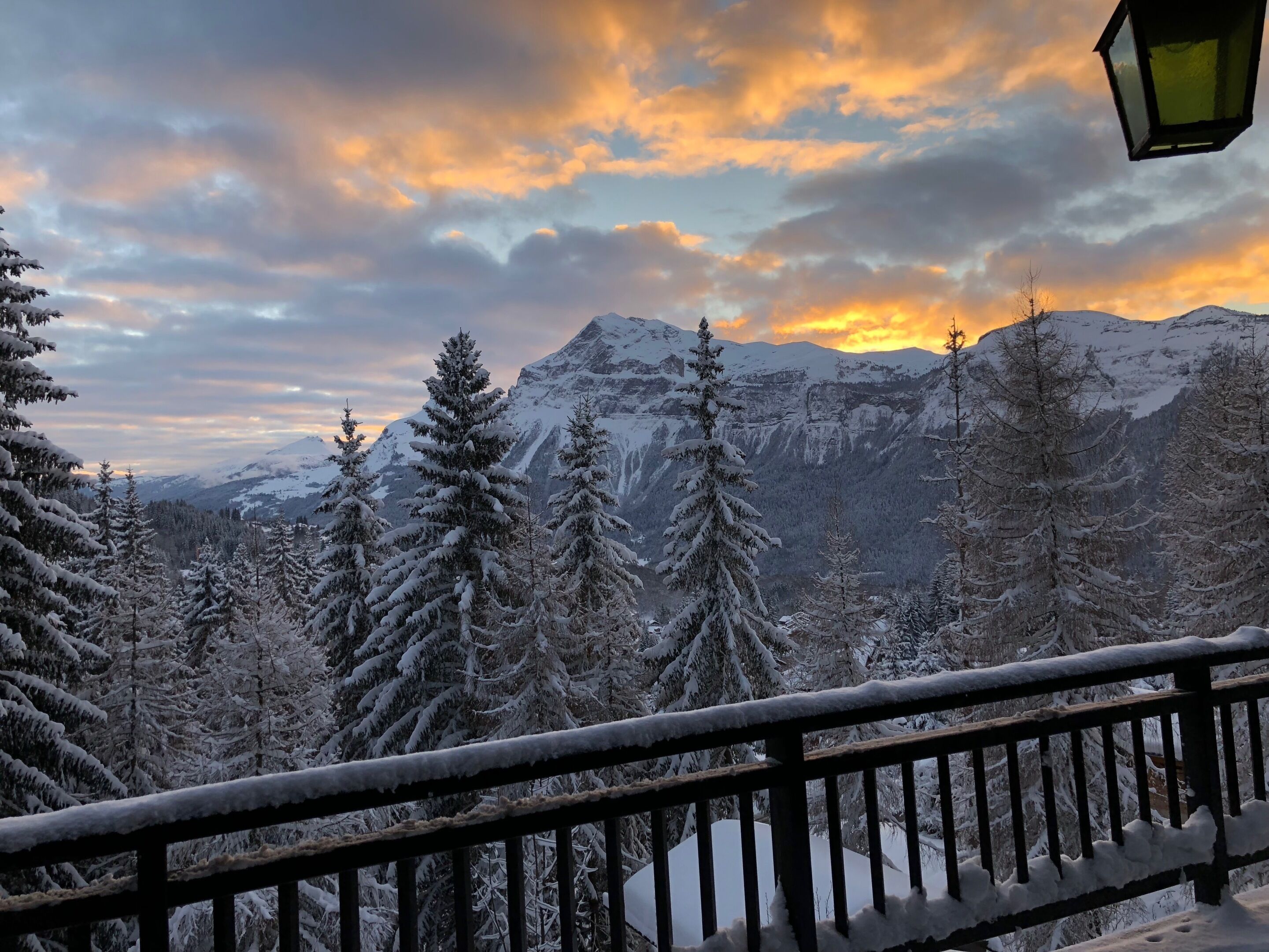 Un paysage de montagne enneigé avec une balustrade en bois sur un balcon.