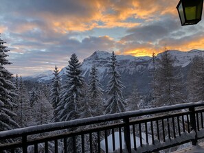 Eine verschneite Berglandschaft mit einem Holzbalkon.