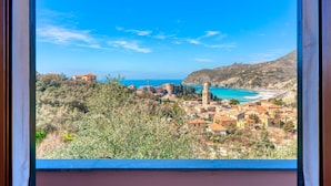 Una cittadina costiera con edifici, un cielo azzurro limpido e vista sul mare.