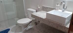 A bathroom with a toilet, sink, and shower. - Beach house in gated community, 2 suites, air conditioning, barbecue, 2 swimming pools. (São Sebastião)