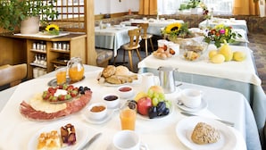 A breakfast setting with a variety of foods, including fruits, pastries, and a selection of beverages. - Mittendorf Klimaresidence (Schenna)