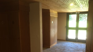 A room with a stone floor, wooden walls, and a door leading outside. - Studio, at the foot of the Belle Plagne slopes, sleeps 4, wifi included. (La Plagne Tarentaise)