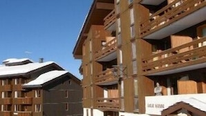 A multi-story hotel with a wooden facade, balconies, and a sign reading "AHLER HOUSE". - Studio, at the foot of the Belle Plagne slopes, sleeps 4, wifi included. (La Plagne Tarentaise)