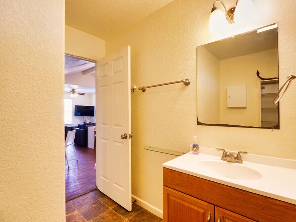 A bathroom with a white sink, a mirror, and a towel rack. - Decks Galore Gulf Views As Far As The Eye Can See (Freeport)