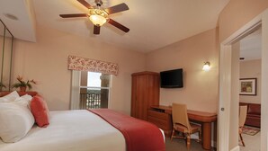 A hotel room with a bed, a desk, a chair, a television, and a ceiling fan. - 7 Days / 6 Nights Gateaway (Kissimmee)